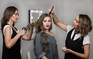 girl getting her hair done by two professionals