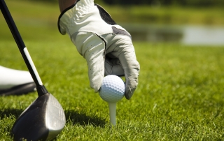 golfer placing ball on tee