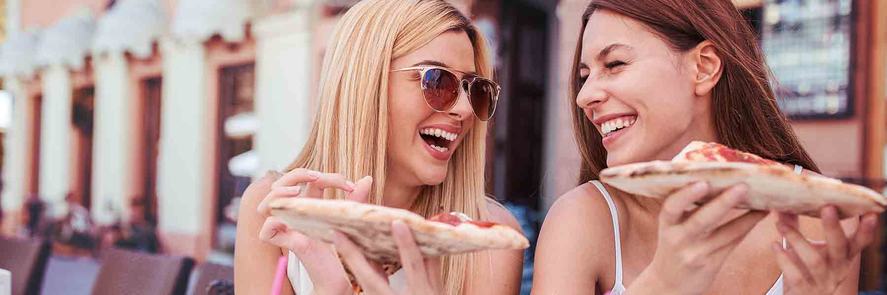 Women smiling eating pizza